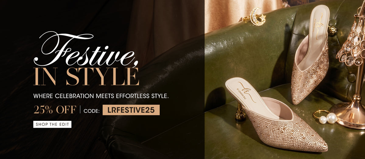 A promotional fashion banner featuring a pair of pointed-toe heeled mule shoes covered in sparkling gold rhinestones, styled on an olive green leather sofa with decorative jewelry and a gold stand. The left side contains large white and gold text reading 'Festive, in Style' and '25% OFF code: LRFESTIVE25'.